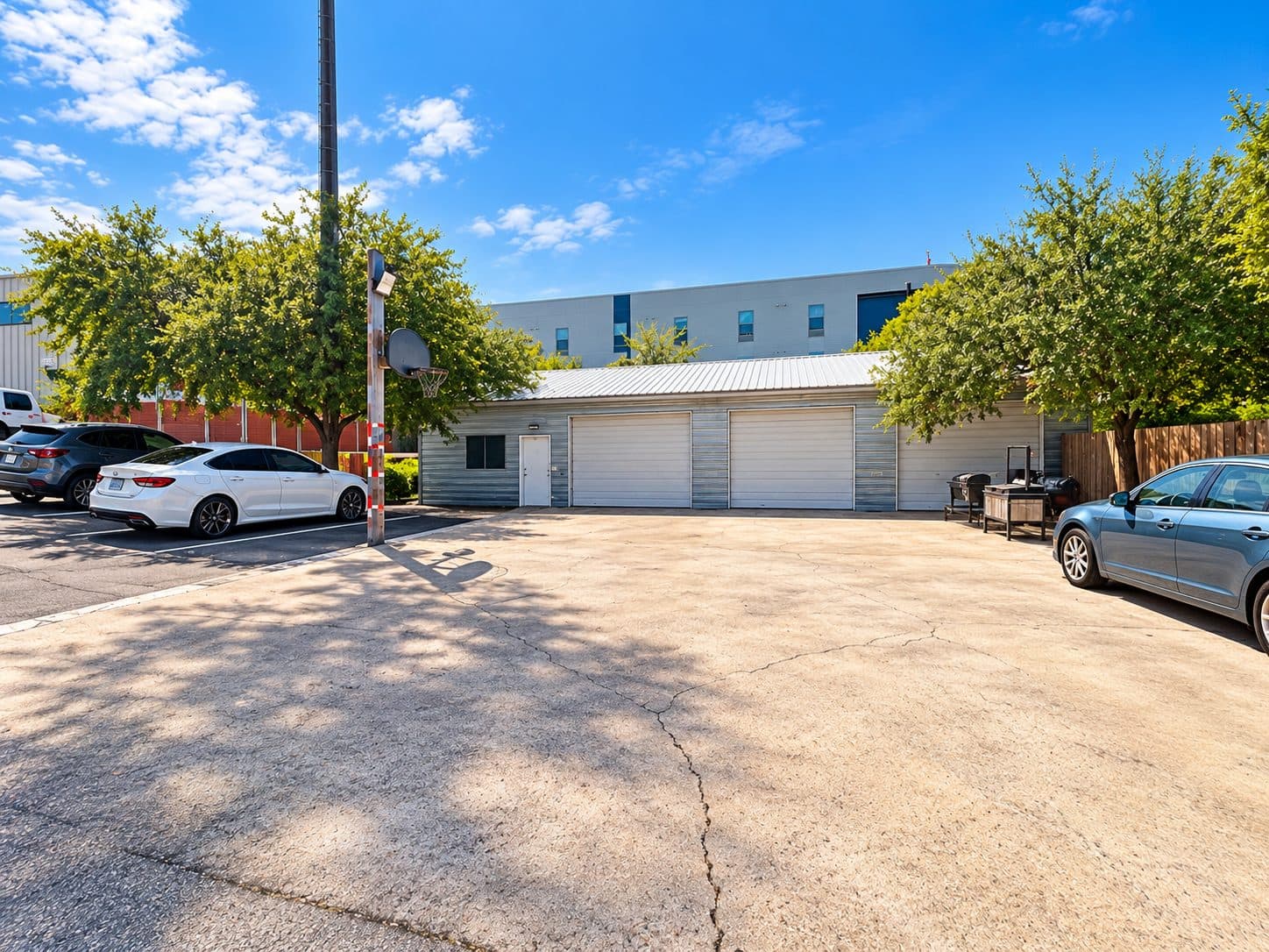 Paved parking lot in front of the studio building with cars parked along the edges